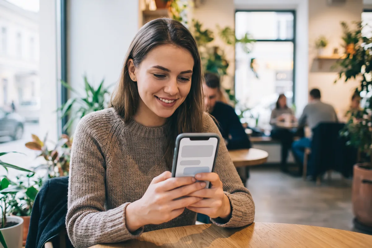 Young woman receiving a message notification on her smartphone